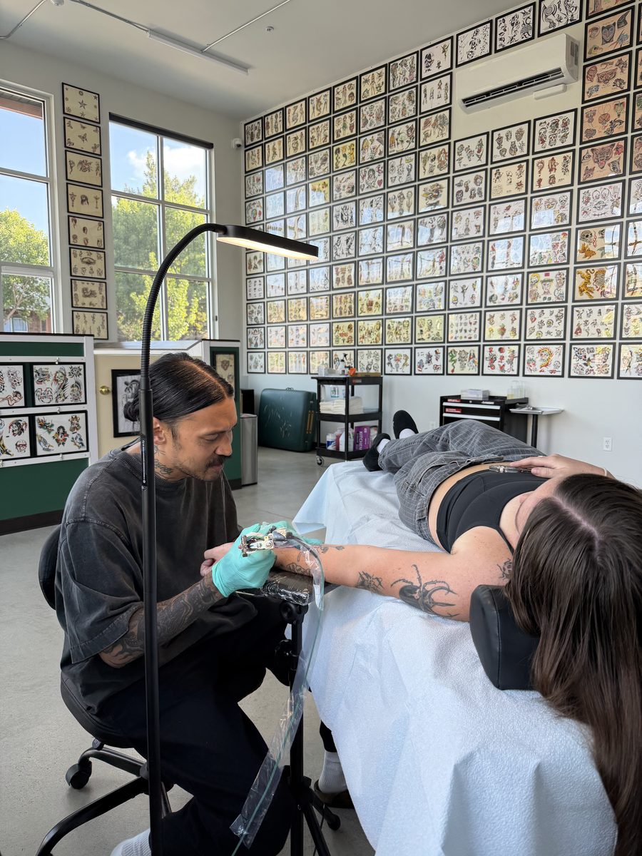 Pokii Palicte tattooing a client